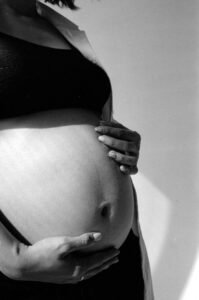 pregnant woman gently holding her belly