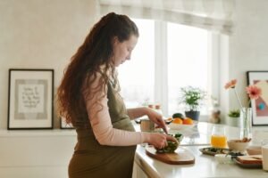 pregnant woman preparing healthy food in her kitchen